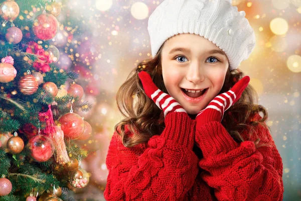 Μικρό κορίτσι σε ρούχα χειμώνα έκπληκτος κοντά στο χριστουγεννιάτικο δέντρο — Φωτογραφία Αρχείου