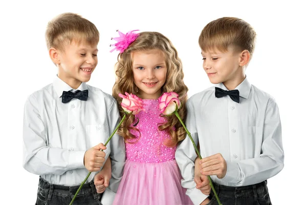 Два мальчика-близнеца дарят цветы красивой маленькой девочке — стоковое фото