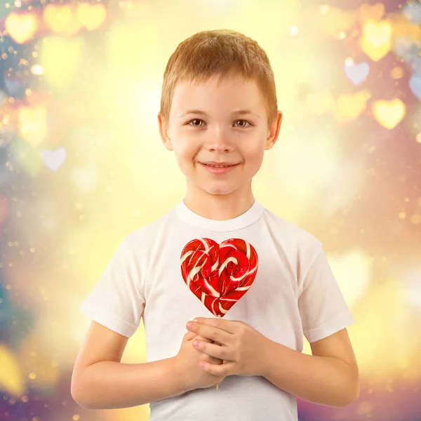 Niño pequeño con caramelo lollipop rojo en forma de corazón. Retrato de arte de San Valentín . —  Fotos de Stock