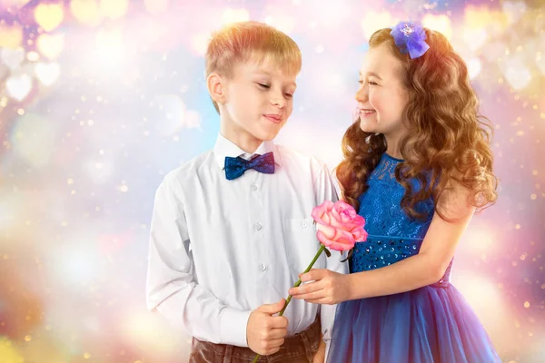 Lindos niños, chico da una niña de flores. Día de San Valentín. Amor infantil — Foto de Stock