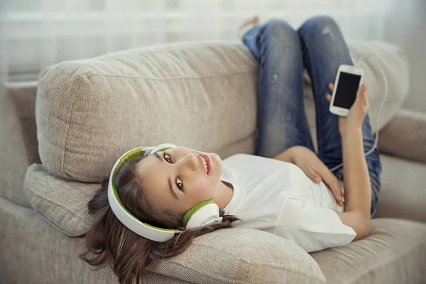 Teenager-Mädchen mit Smartphone und Kopfhörer hören Musik und unterhalten sich in sozialen Netzwerken — Stockfoto