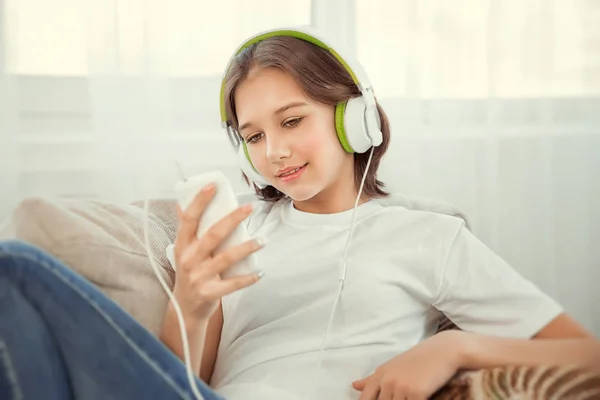 Όμορφο κορίτσι εφηβικής με smartphone και ακουστικά ακούγοντας μουσική. — Φωτογραφία Αρχείου
