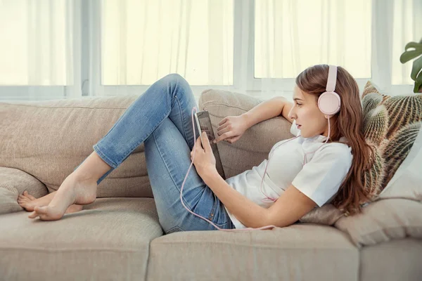 Schöne Teenager-Mädchen mit Tablet-PC und Kopfhörer Musik hören. — Stockfoto