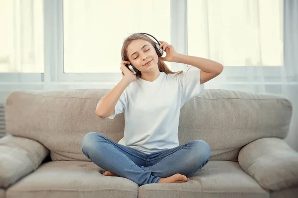 Schöne Teenager-Mädchen mit Smartphone und Kopfhörer Musik hören. — Stockfoto