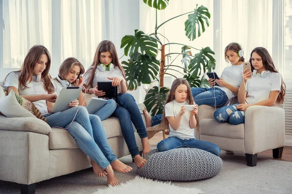 Niños con teléfonos y tabletas, con teléfonos inteligentes y auriculares. Grupo de chicas adolescentes está utilizando gadgets . — Foto de Stock