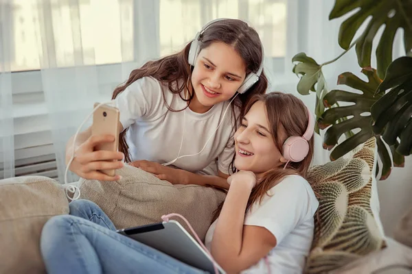 Teenager-Mädchen mit Tablet-PC und Kopfhörern hören Musik und kommunizieren in sozialen Netzwerken — Stockfoto