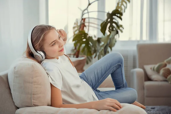 Schöne Teenager-Mädchen mit Smartphone und Kopfhörer Musik hören. — Stockfoto