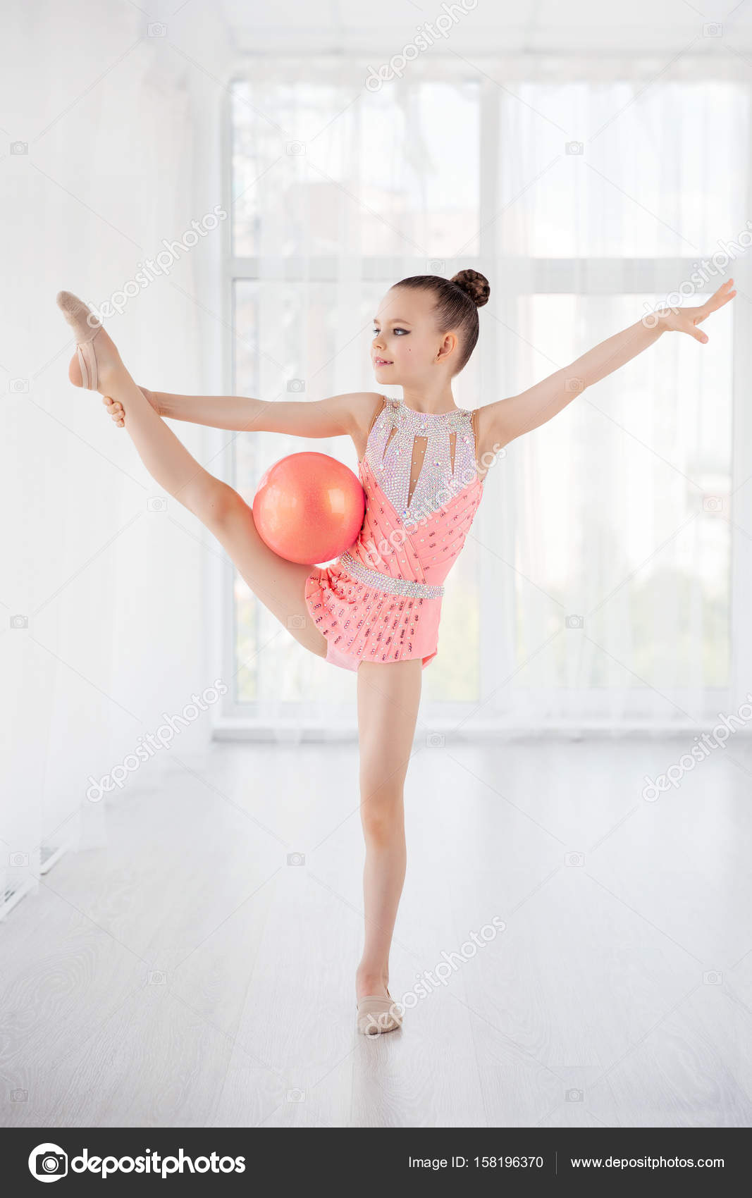 Hermosa nina gimnasta en vestido de ropa deportiva rosa la realizacion de elemento de gimnasia de arte con pelota en la clase de fitness Foto de stock 158196370 SvetaOrlova