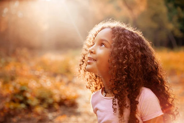 Afro americana linda niña con pelo rizado recibe milagrosos rayos de sol del cielo — Foto de Stock