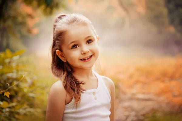 Gyermekek mosolyog a boldogság fogalmát. Kültéri portré egy aranyos mosolygós kislány. — Stock Fotó
