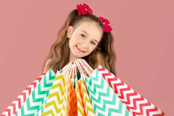 Venta. Linda niña con muchas bolsas de compras. Retrato de un niño de compras . — Foto de Stock