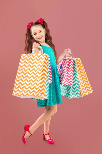 Venta. Linda niña con muchas bolsas de compras. Retrato de un niño de compras . —  Fotos de Stock