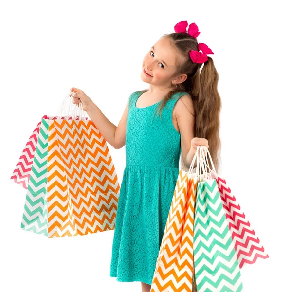 Verkoop. Schattig klein meisje met veel boodschappentassen. Portret van een ki — Stockfoto