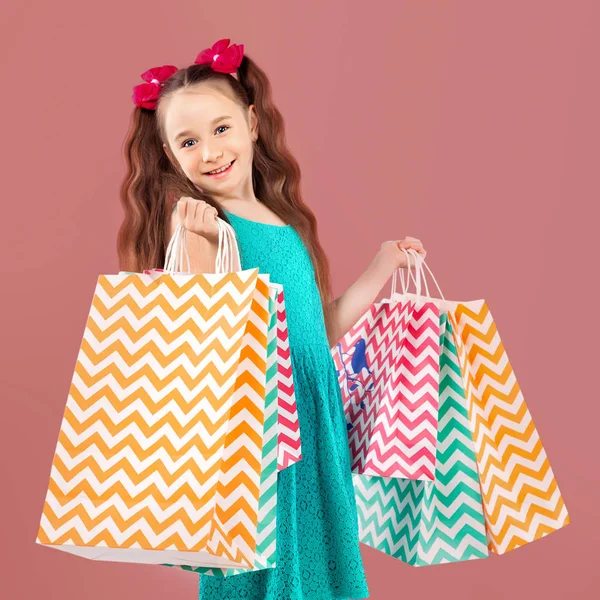 Venda. Menina bonito com muitos sacos de compras. Retrato de um ki — Fotografia de Stock