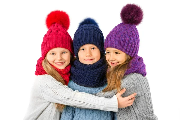 Skupina roztomilé děti v zimě teplé čepice a šály izolované na bílém. Dětské zimní oblečení — Stock fotografie