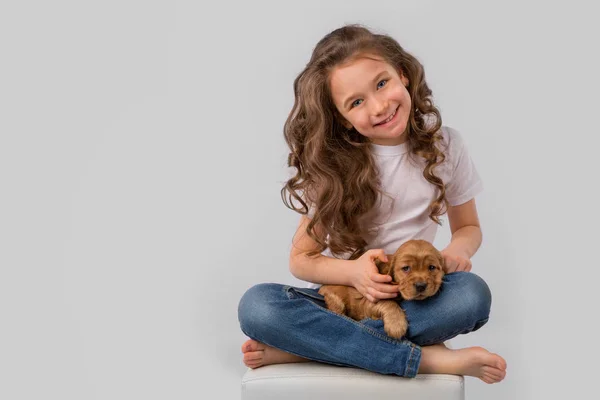 Концепция детской дружбы - маленькая девочка с красным щенком, изолированным на белом фоне — стоковое фото
