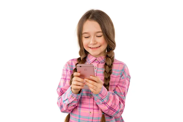 Una niña dulce jugando juegos en su teléfono móvil aislado sobre fondo blanco Imagen de archivo