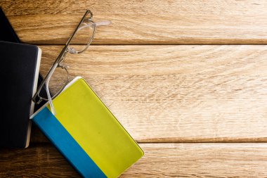 Drei Buecher auf Holz Hintergrund