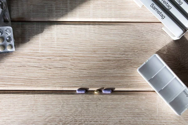 Tablettenspender auf einem Holzboden — Stockfoto
