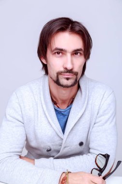 Genç çekici adam suggestively gözlük tutan kameraya bakıyor