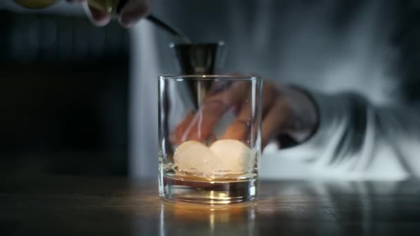 Barkeeper schüttet Whiskey in den Jigger — Stockvideo