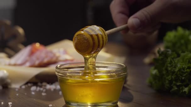 Chef sumerge palo de miel de madera en el tazón de vidrio — Vídeo de stock