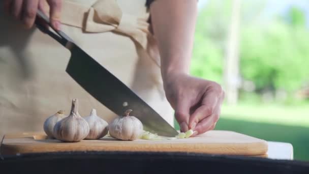 Szef kuchni strzępy czosnku na desce drewnianej — Wideo stockowe