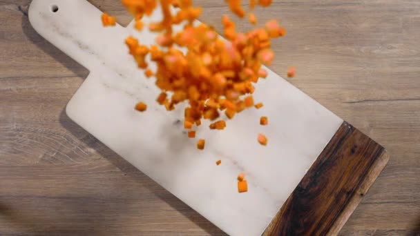 Krájená mrkev padá ve zpomaleném pohybu na skálu — Stock video