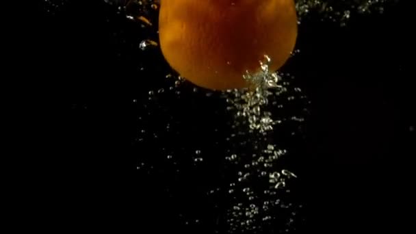 Fallande apelsin i vatten — Stockvideo