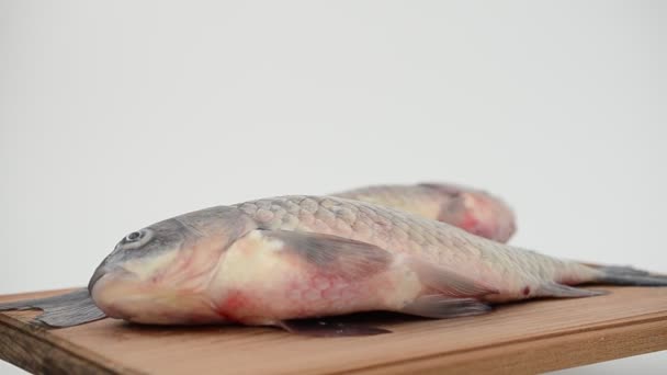 Pescado sobre la mesa sobre una tabla de madera — Vídeos de Stock