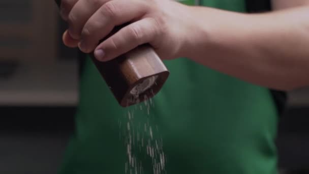 Makro Shot Koch verwendet Salzmühle, um etwas Salz hinzuzufügen — Stockvideo