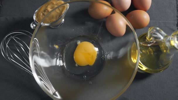 Сырое яйцо падает в тарелку, делая майонез — стоковое видео
