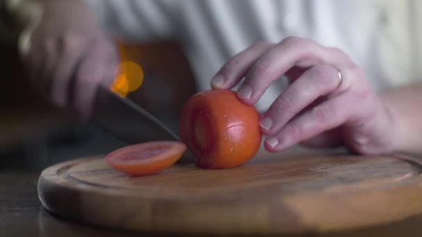 O cozinheiro corta tomates vermelhos frescos na tábua de madeira — Vídeo de Stock