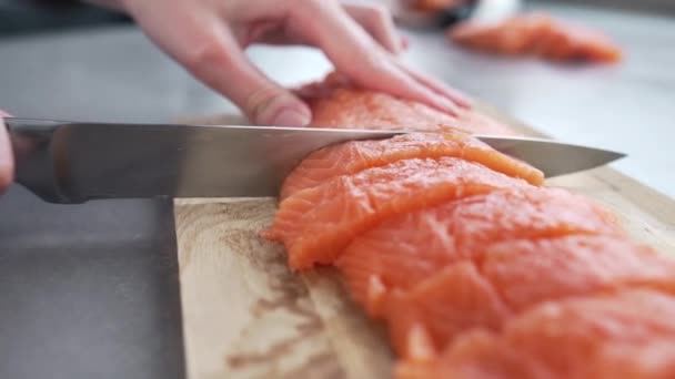 Повар режет филе лосося повар готовит рыбу — стоковое видео