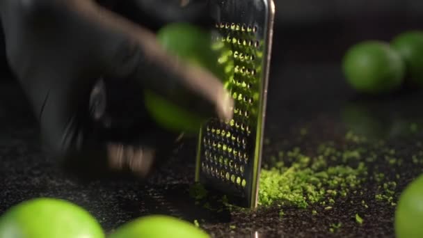 De kok raspt rijpe limoenen op de rasp te krijgen lust voor het koken dessert — Stockvideo