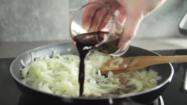 Повар готовит вкусное блюдо с обжаренным луком — стоковое видео