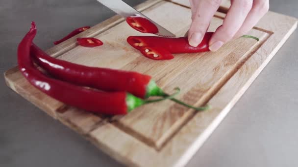El cocinero corta chiles picantes en la tabla de madera — Vídeos de Stock