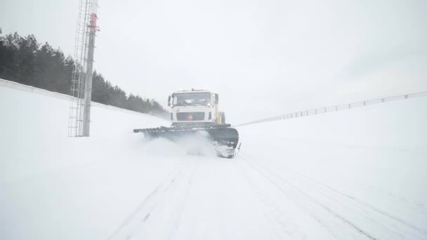 Грузовик для удаления снега и льда убирает снег с дороги — стоковое видео