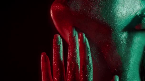 Modeporträt einer Frau, die ihren Hals mit den Fingerspitzen im Glitzern und im Neonlicht berührt — Stockvideo