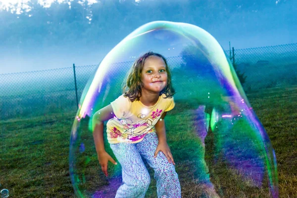 Девушка в мыльном пузыре — стоковое фото