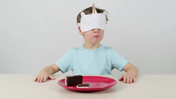 Kleiner Junge Maske Probiert Schokoladenkuchen Mit Weißer Sahne Stockbild