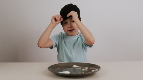 一个戴着黑色面具的男孩试着猜各种各样的食物 然后竖起大拇指 — 图库视频影像