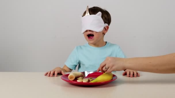 Kleiner Junge Maske Versucht Banane Erraten — Stockvideo