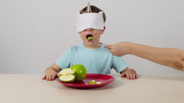 Kleine Jongen Een Masker Probeert Raadt Groene Appel — Stockvideo