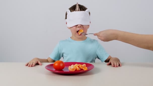 Kleine Jongen Met Een Masker Probeert Raadt Mandarijn — Stockvideo