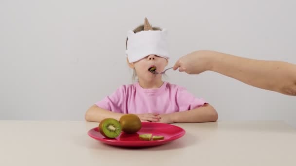 Niña Una Máscara Intenta Adivina Kiwi Verde — Vídeo de stock