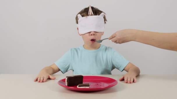 Niño Una Máscara Intenta Adivina Pastel Chocolate Con Crema Blanca — Vídeos de Stock