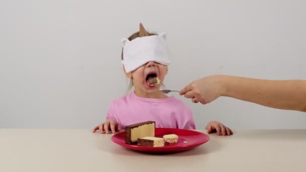 Liten Flicka Mask Försöker Och Gissningar Våfflor Med Choklad — Stockvideo