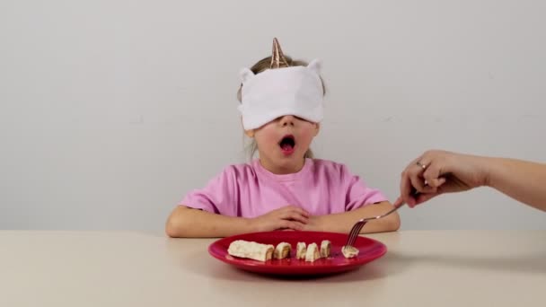 戴面具的小女孩试图用白巧克力猜华夫饼吧 — 图库视频影像