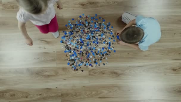 Kinderen Maken Een Puzzel Thuis Vloer Bovenaanzicht Slow Motion — Stockvideo